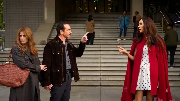 Amsterdam Empire TV show screenshot: A well-dressed man and woman stand in front of wide concrete steps pointing fingers at each other