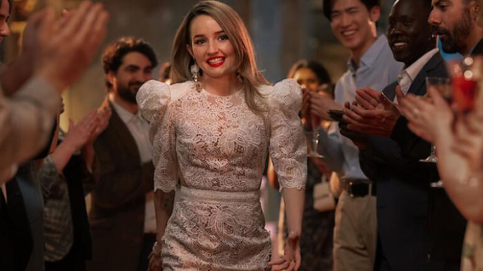 Apple Cider Vinegar TV show screenshot 2: Belle is seen in glamorous designer clothing, entering an upscale event with guests applauding her.