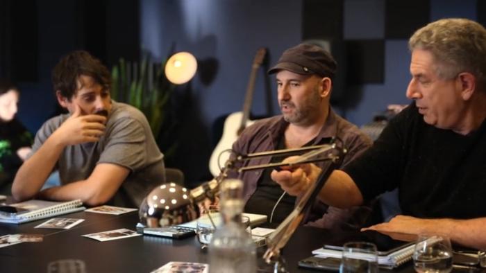 James Diener and Ken Levitan sit at a conference table. Diener wears a brown cap and brown shirt. Levitan wears a black shirt.