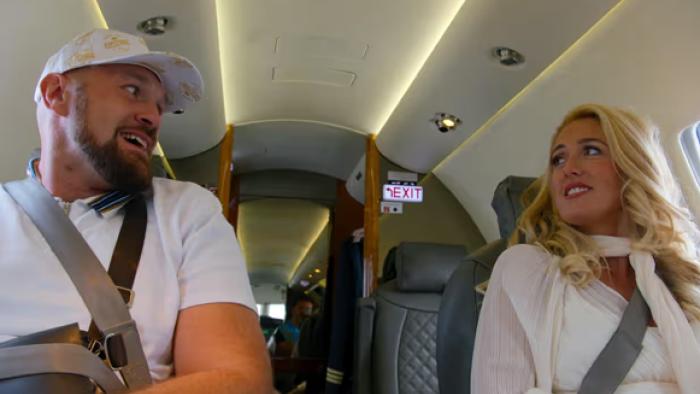 At Home with the Furys TV show screenshot: Tyson Fury and his wife, Paris, look at each other while sitting on a private airplane.