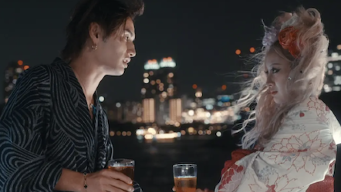 Badly in Love TV show screenshot 3: A male participant talks to female participant at night overlooking skyline. 