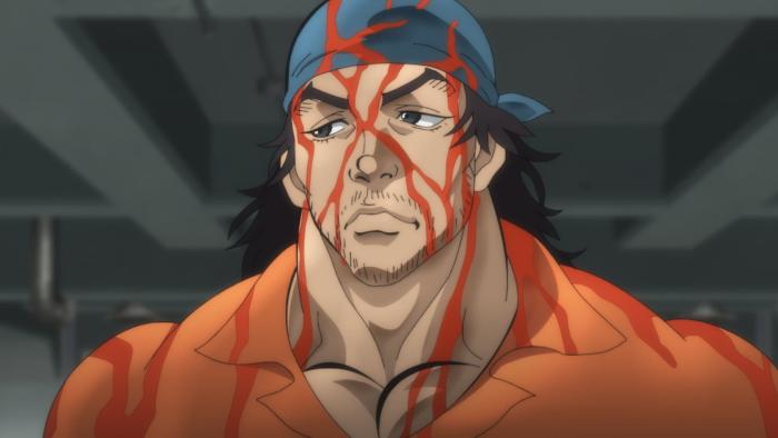 Baki Hanma TV show screenshot 3: a man in an orange prison suit and blue bandana frowns while blood pours down his head