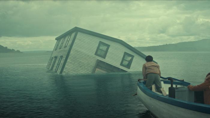 Below TV show screenshot: People in a rowboat watch as a house sinks in the water