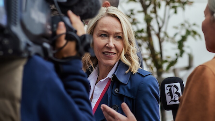 Billionaire Island screenshot 1: Julie Lange talks to reporters. 