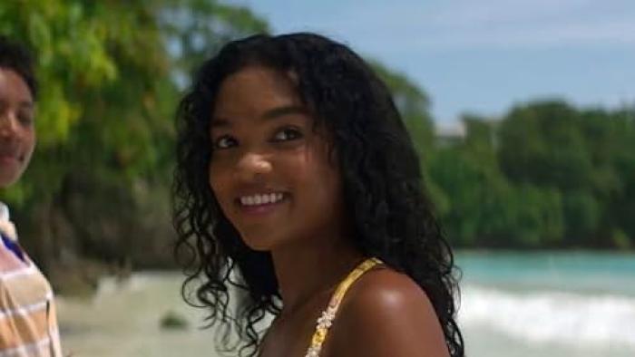 Black Cake TV show screenshot: Close up of a pretty teenage black girl smiling on the beach.