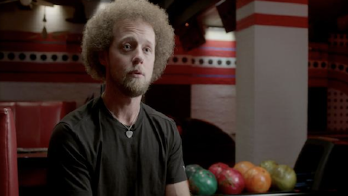Born to Bowl TV show screenshot 1: Kyle Troup in black shirt with Afro-like red hair.