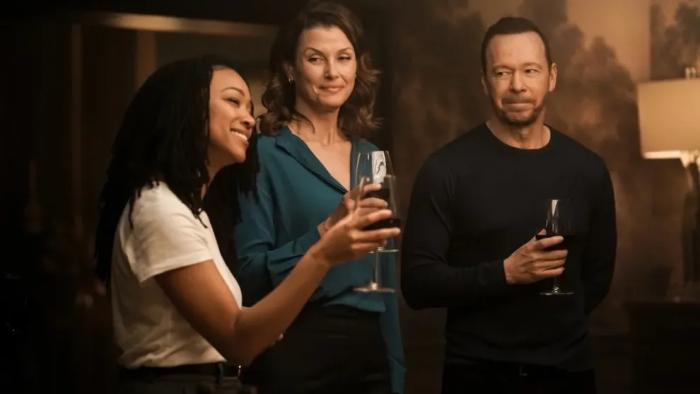 Boston Blue: Donnie Wahlberg, Bridget Moynahan and Sonequa Martin-Green toast over dinner. 