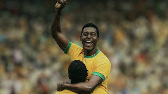 Brazil ’70: The Third Star screenshot 1: Péle celebrates celebrating with arm raised, wearing yellow jersey in crowded stadium.