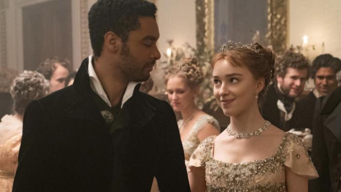 Bridgerton Season 1 TV show screenshot 1: Simon and Daphne are pictured at a social event, looking in each other's eyes and smiling