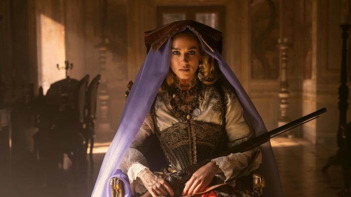 Brigands: the Quest for Gold TV show screenshot: A woman in old western dress and a purple veil holds a shotgun.