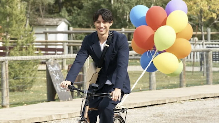 Can This Love Be Translated? TV show screenshot 3: Hiro Kurosawa in black jacket rides bike holding balloons. 
