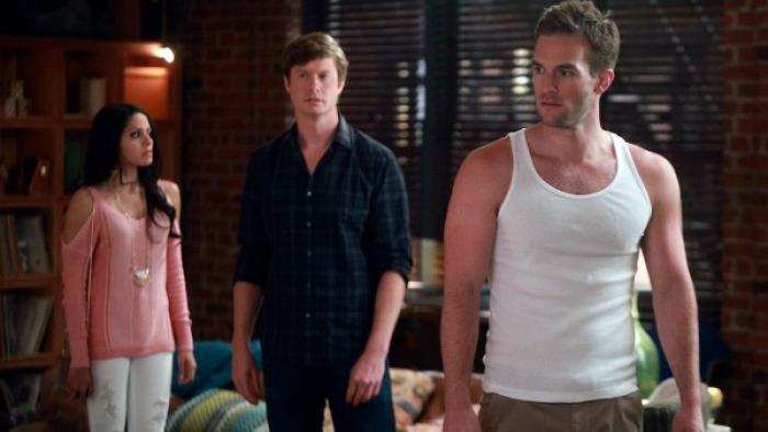Champions TV Series: Three people stand in a darkened living room: two men and a woman, and the woman looks to be angry at one of the men. 