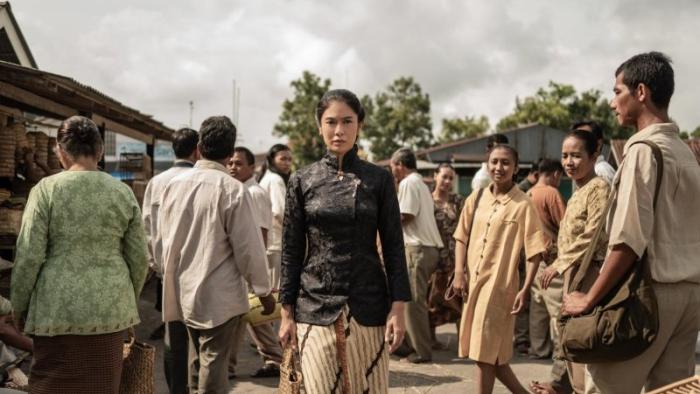 Cigarette Girl TV show screenshot 1: Dian Sastrowardoyo walks in a crowd of people in ‘Cigarette Girl.'