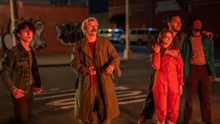 City on Fire TV show: onlookers watch something glowing, maybe a fire, from the sidewalk