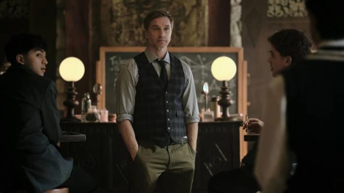 Coven Academy TV show screenshot 2: Mr. Cole instructs students on magic flanked by two students in a classroom