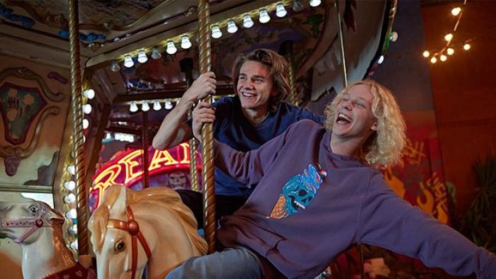 Henry Strand and Stacy Clausen gleefully ride a merry go round.