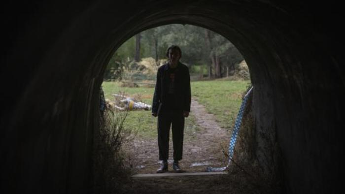 Henry Strand stands at the entrance of a dark tunnel.
