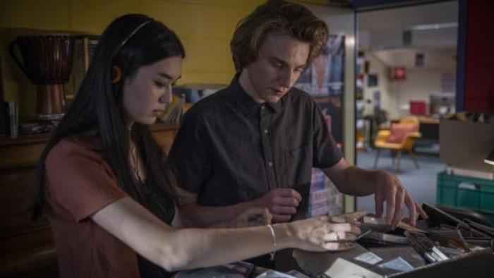 Hannah Ogawa and Henry Strand dig through a box of CD’s together.