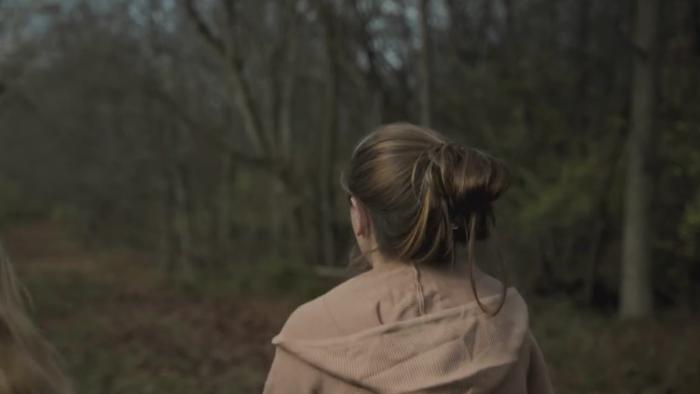 Crime Nation TV show screenshot: The back of a girl is shown walking through the woods.