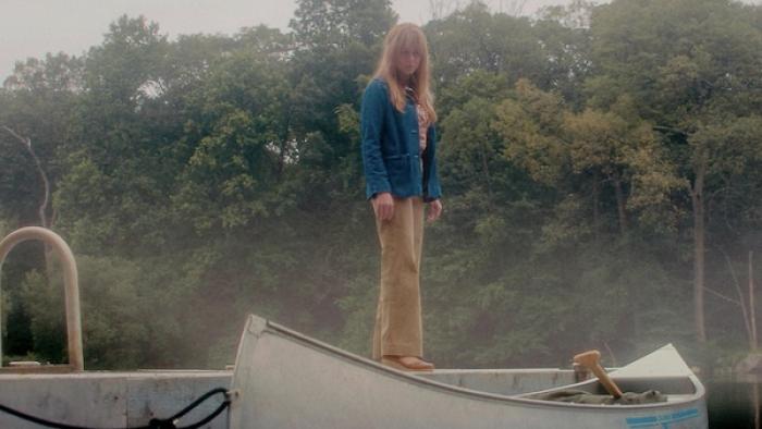 Crystal Lake TV show screenshot 3: Pamela Voorhees standing on a docked canoe, surrounded by misty trees.