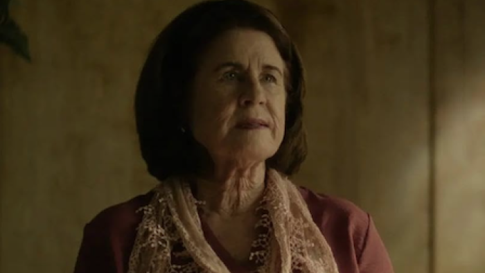 Conversations with a Killer: The Charles Manson Tapes TV show screenshot 1:Dianne Lake gazes thoughtfully, wearing a pink scarf indoors.