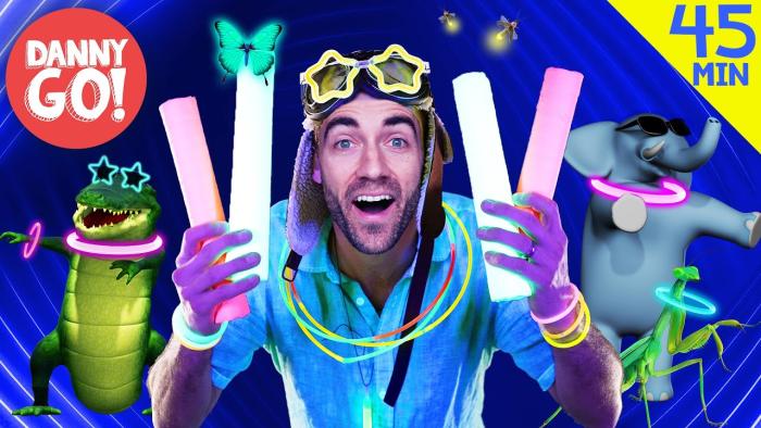 Danny Go! TV show screenshot 1: Danny Go holds up glowing pool noodles with a dancing crocodile and elephant in the background