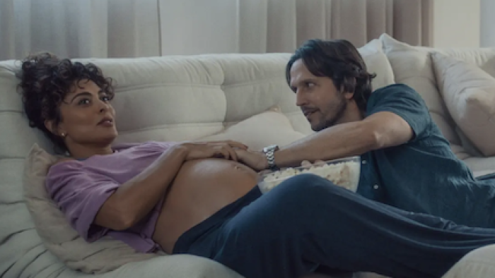 Desperate Lies TV show screenshot 1: Tomás lies on bed and rubs Liana's pregnant belly 