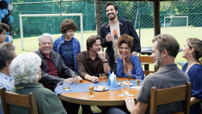 Desperate Lies TV show screenshot 2: family and friends gathered outside around table. 