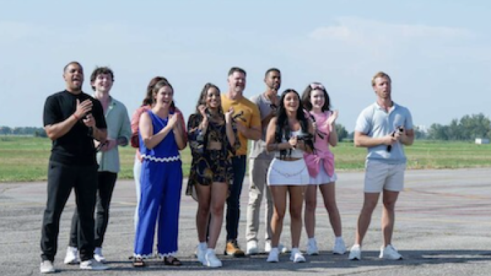 Destination X TV show screenshot 2: Contestants celebrate seeing the bus. 