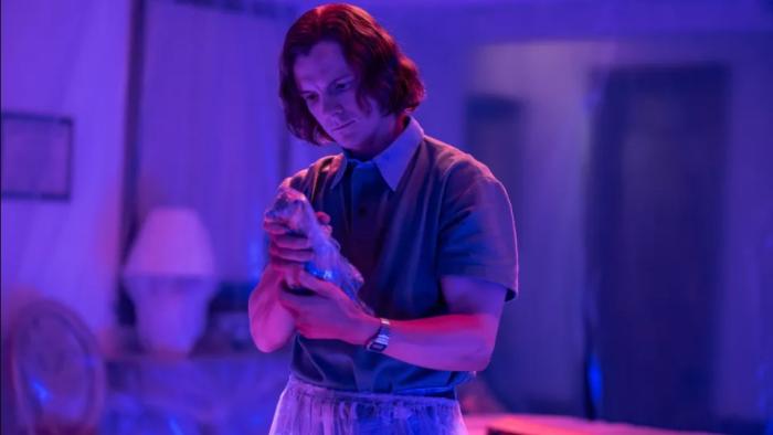 Dexter: Original Sins: young Dexter examines some evidence under blue light