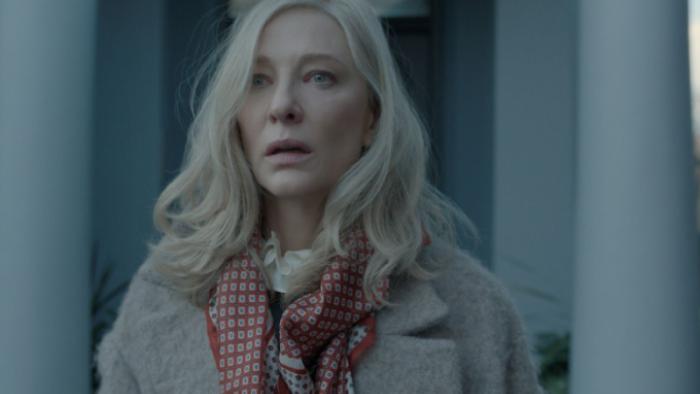 Disclaimer: Catherine stares into the middle distance with a stressed look on her face; the image has a gray cast