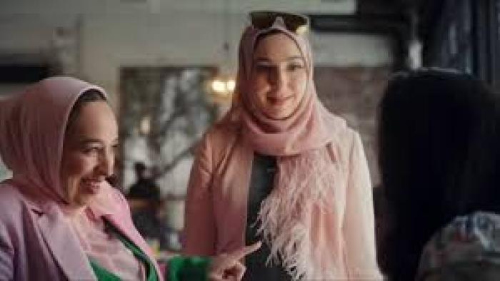 Muslim Matchmaker TV show screenshot: Two Muslim women with pink hijabs and matching pink outfits looking at someone together