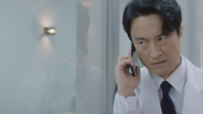 Doctor Cha TV show screenshot 3: Seo In-ho in lab coat hides behind wall to talk on cell phone.