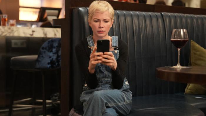 Dying for Sex TV show screenshot 1: Molly is center frame, looking at something on her phone in dismay