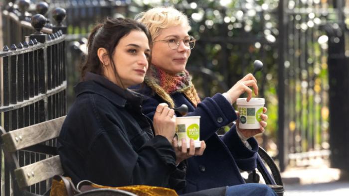 Dying for Sex TV show screenshot 3: Nikki and Molly sit close together on a park bench, looking at something off-camera