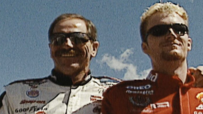 Earnhardt TV show screenshot 3: Dale Earnhardt, Sr. in white with arm around shoulders of Dale Earnhardt, Jr. wearing red.