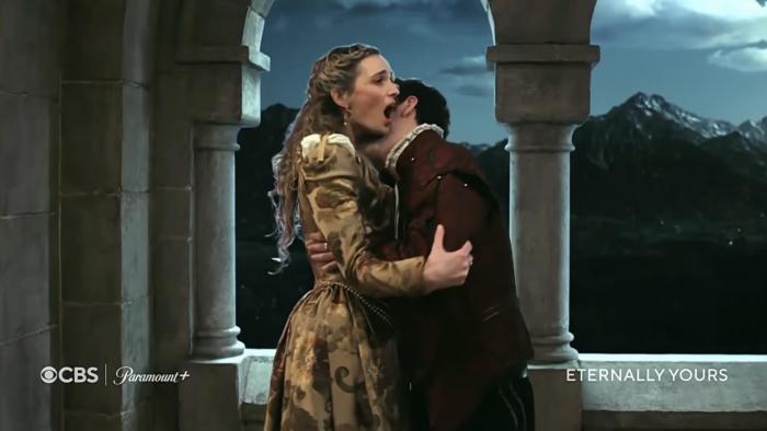 Eternally Yours TV show screenshot: A couple in historic costumes embraces on a castle balcony at night.