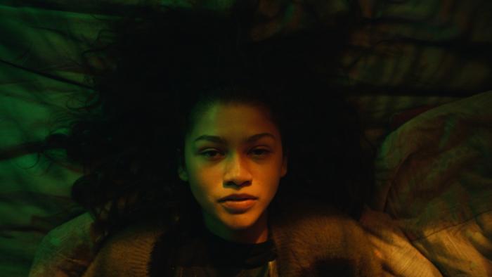 Euphoria TV Series: A closeup of Rue's face, lit by an eerie greenish light 
