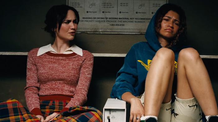 Euphoria Season 3: Lexi and Rue sit together at home; Rue has her knees drawn up and Lexi appears to be disgusted