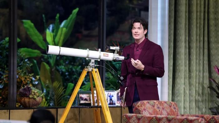 Everybody's Live with John Mulaney TV show screenshot 1: Mulaney stands at his telescope