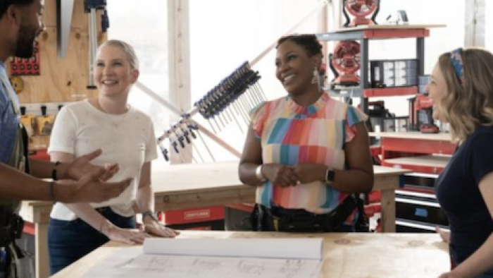 Extreme Makeover: Home Edition (2025) screenshot 1: Wendell, Clea, Arianne, and Joanna stand around table looking at building plans. 