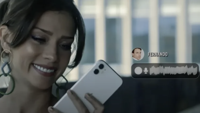 Fake Profile TV show screenshot 2: Smiling Camila looks down at white cell as text and recording CGI appear. 