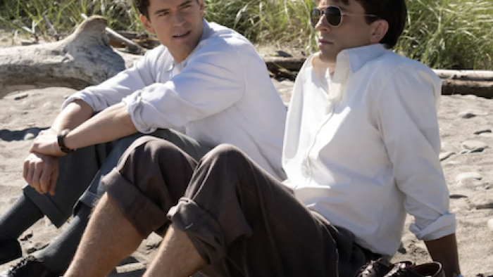 Fellow Travelers TV show screenshot 1: Hawks and Tim sit on the beach and talk. 
