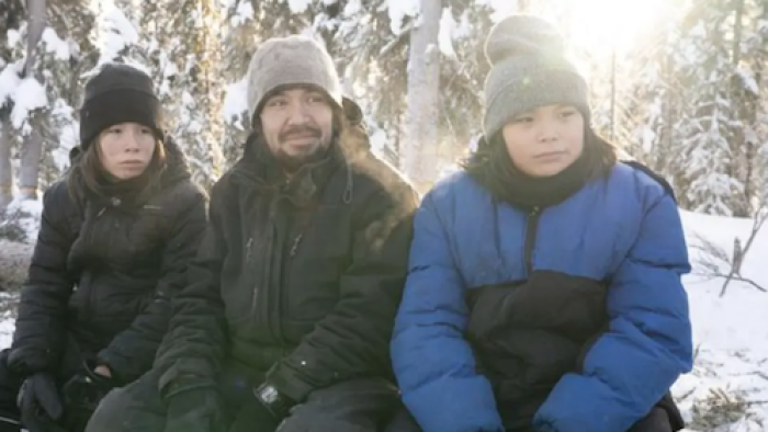 First Alaskans: Steven “Tig” Stressbert sits outside in snow jackets with two of his children.