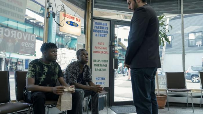Full Circle TV show screenshot 3: a man addresses two Ghanian immigrants in a storefront