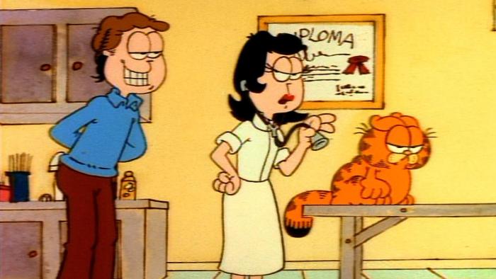 Garfield's Thanksgiving TV: Dr. Liz examines Garfield at the vet while Jon looks over her shoulder, willingly.