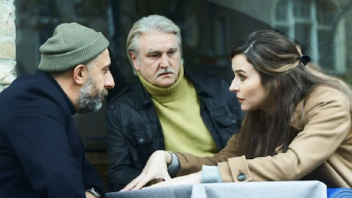 German Genius TV show screenshot 2: Ramadan sits around table with others discussing project problems. 