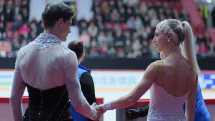 Glitter & Gold screenshot 2: Paul Poirier and Piper Gilles holding hands before stepping on the ice.