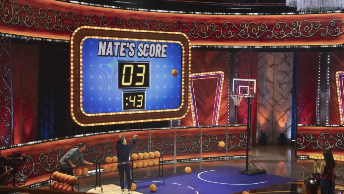 Greatest Average American TV show screenshot: Wide shot of a gameshow sound stage showing a man shooting on a basketball hoop