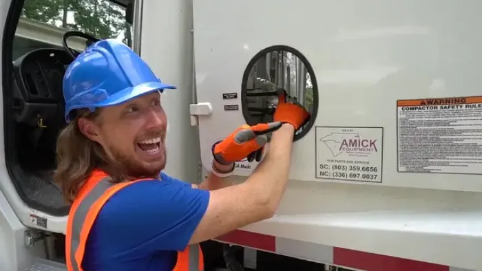 Handyman Hal TV: Handyman Hal in blue hard hat and orange vest smiling as he operates a truck lever.